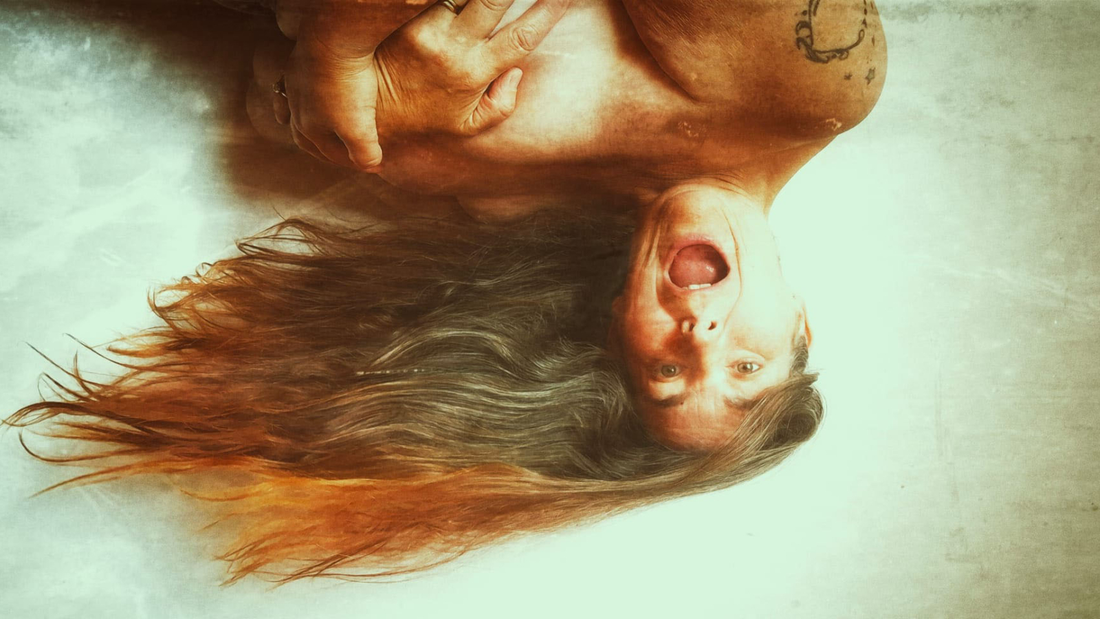 Alison upside down with her mouth open and her hair flowing off to the side for post about how blogging started
